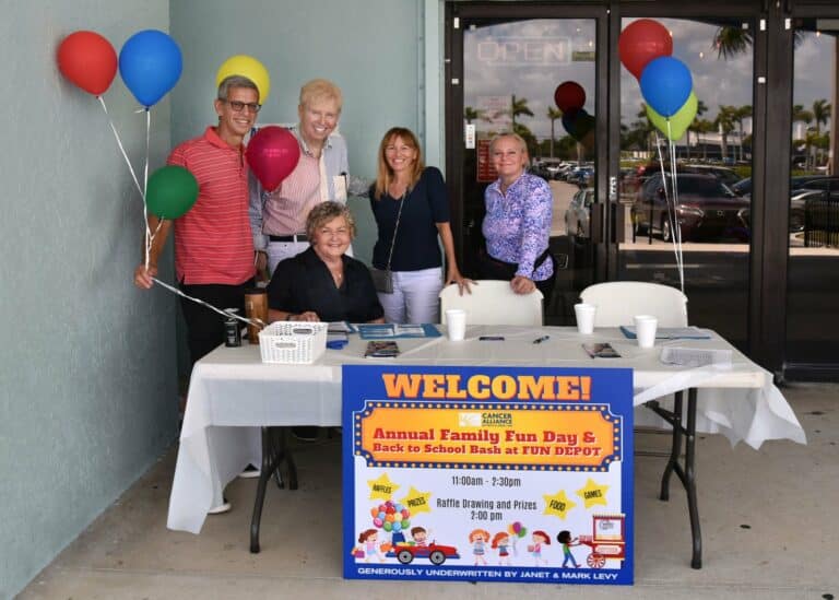 attendees standing at table with balloons